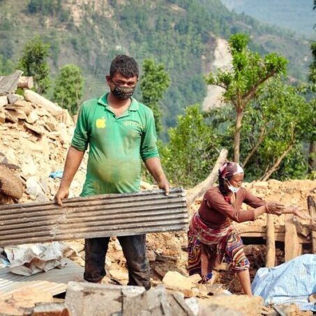 A lady and man removing debris wearing masks