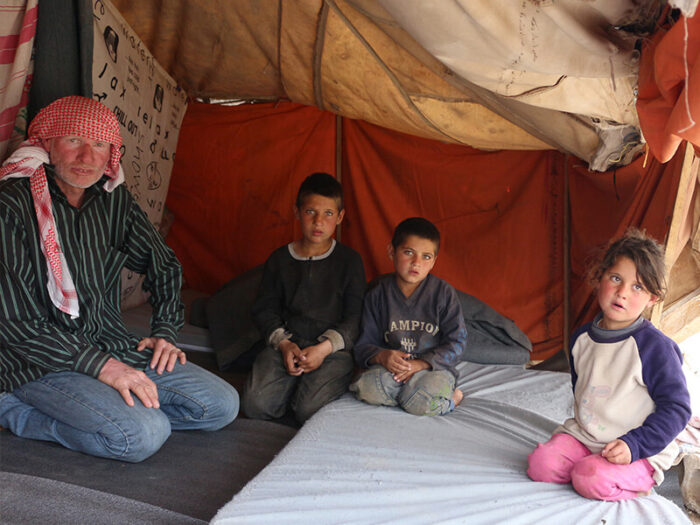 A father with his 3 children inside a tent in Syria