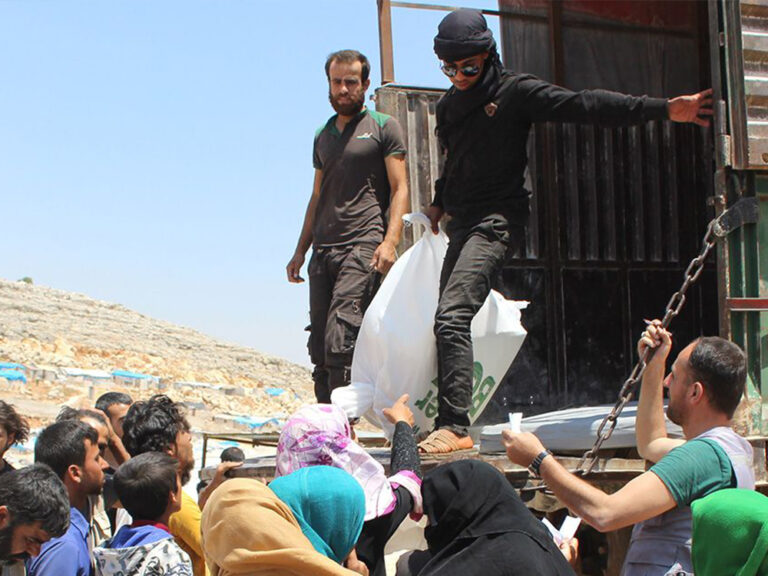 aid workers in syria on back of truck