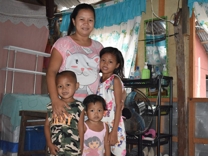 A woman posing hugging her children