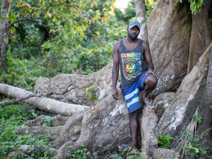 Man standing against a tree