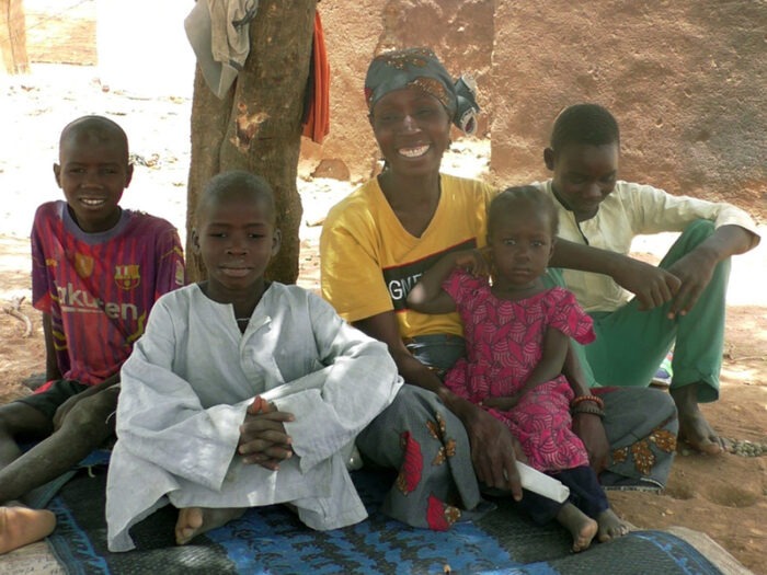 Woman smiling surrounded by children