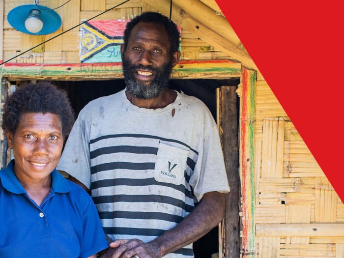 woman in blue top and man in stripey top outside home in vanuatu