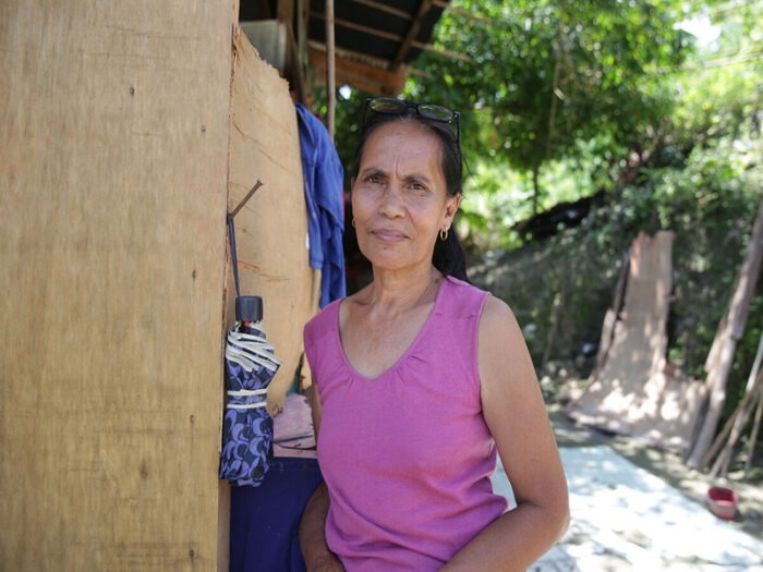 Violeta looking at the camera, outside her home in Cebu