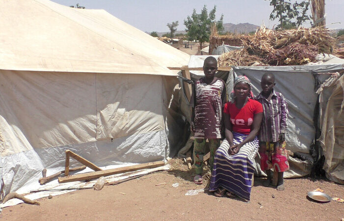Woman and boys outside a tent in Cameroon