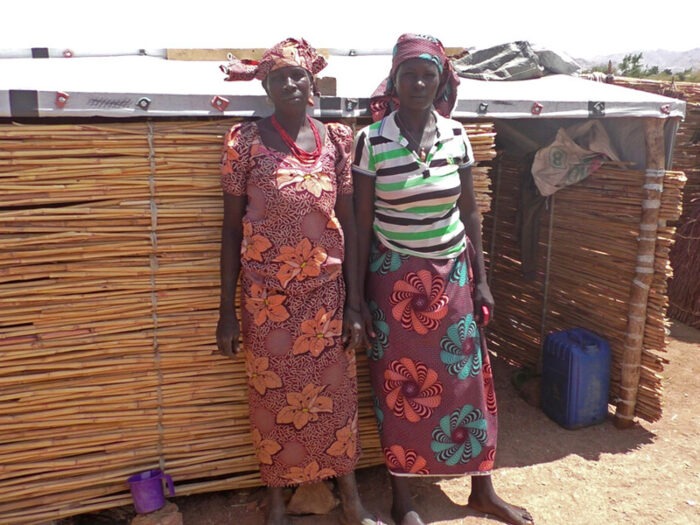 Two women standing next to a house in Cameroon