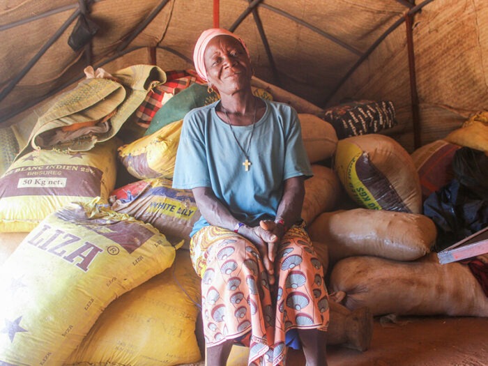 Woman sitting on bags of gravel inside a shelter