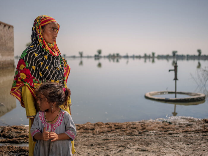 Woman and child looking over flood waters in Pakistan