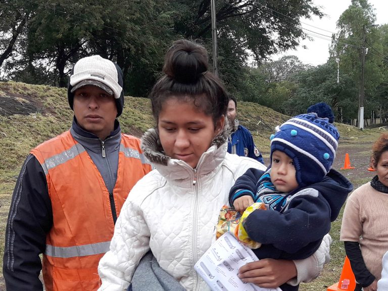 Woman carrying child and aid in Paraguay