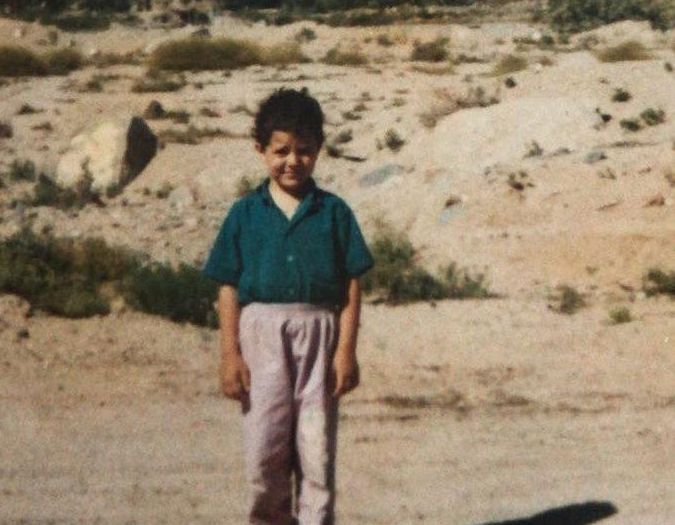 Boy wearing a blue shirt and brown trousers