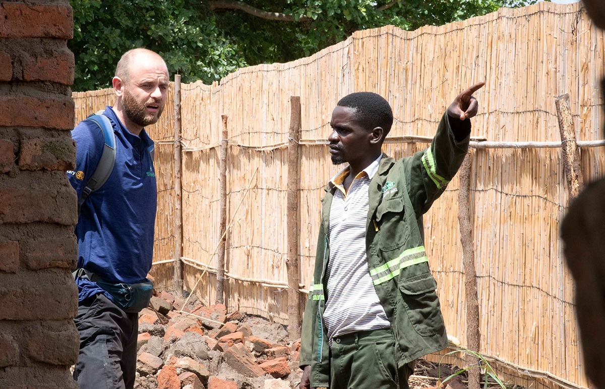 Two men waking round damaged building in Malawi