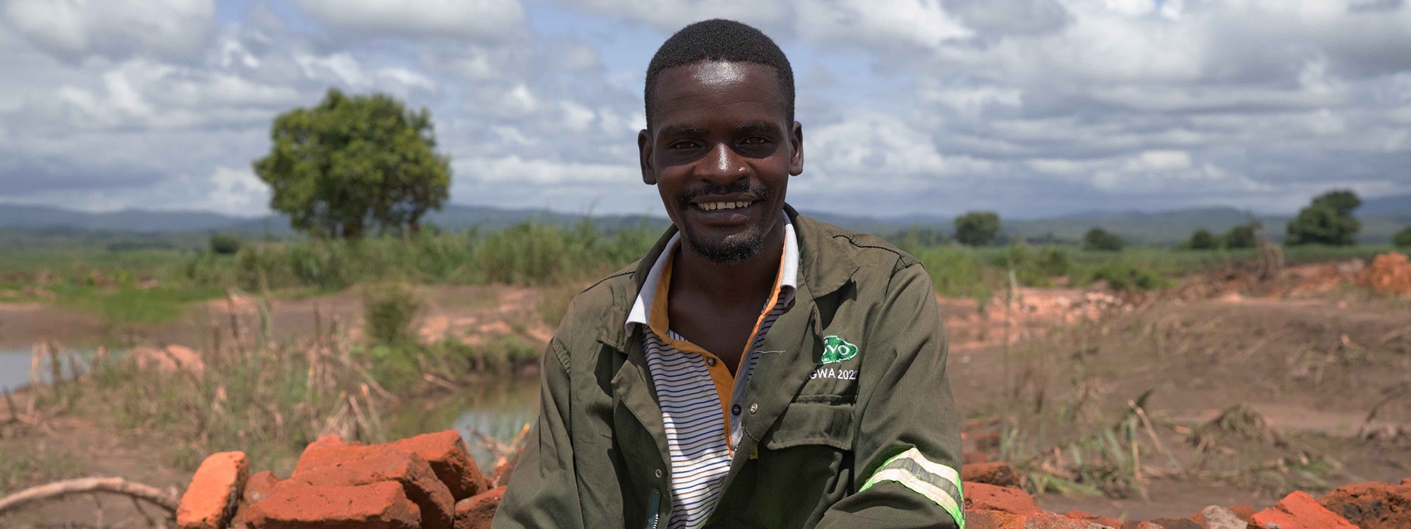 Man sitting on a pile of bricks in Malawi