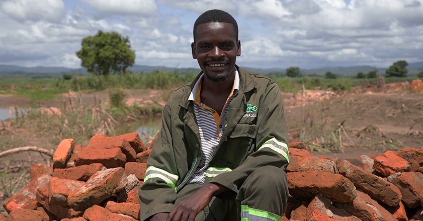 Man sitting on a pile of bricks in Malawi