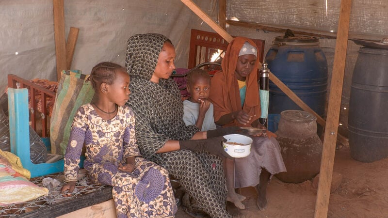 A family in a semi-durable shelter in Chad, built for people who've fled the Sudan war.
