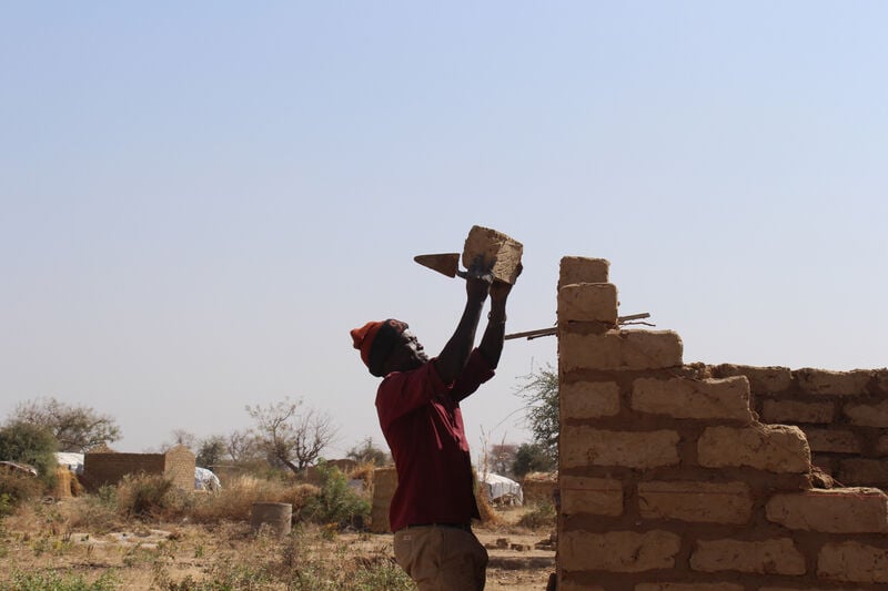 A man building a temporary shelter in Cameroon.
