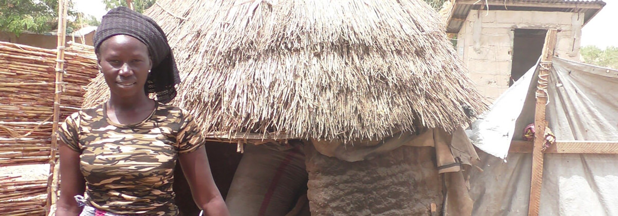 A woman standing outside an emergency shelter in Cameroon.