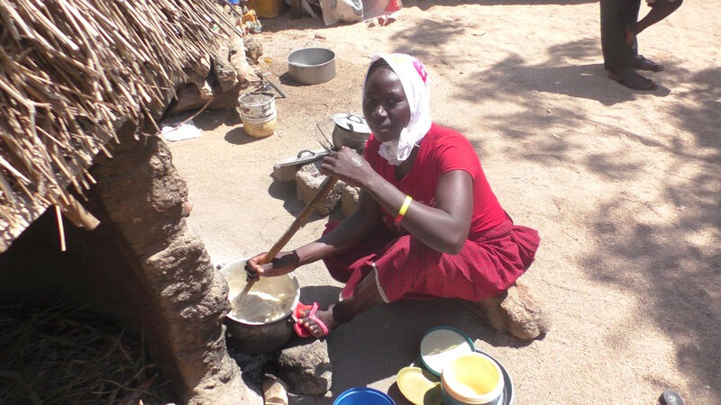A woman sat cooking in a displacement camp in Cameroon.