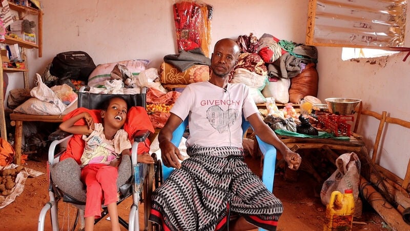A man with his daughter in a shelter. 