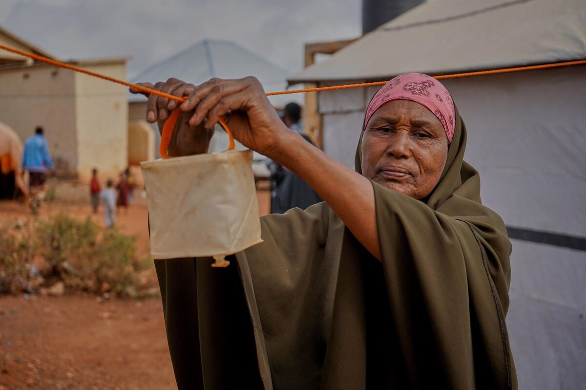 A woman hanging a solar light in Somalia.