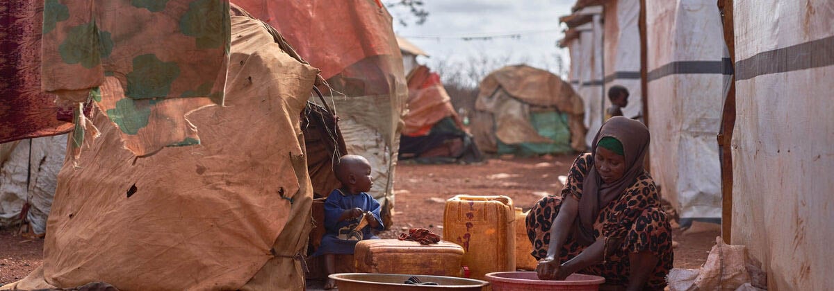 A woman and child washing things in a displacement camp in Somalia.
