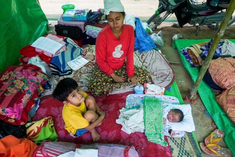 A woman with her two children in an emergency shelter.