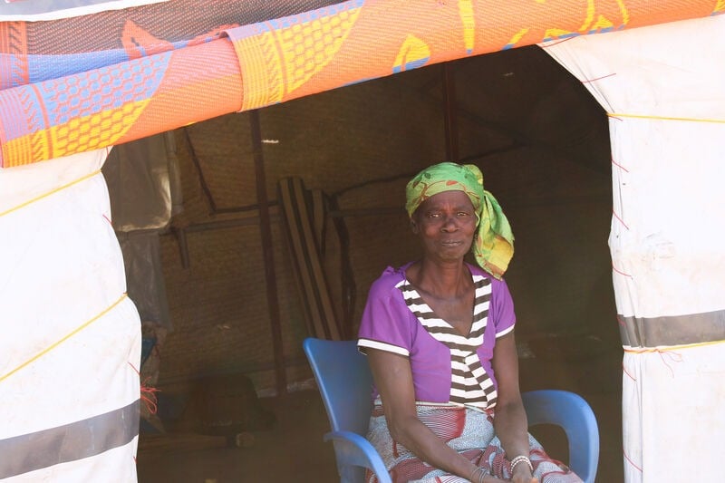 A woman sitting in an emergency shelter.