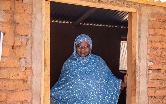 A woman smiling in her doorway.